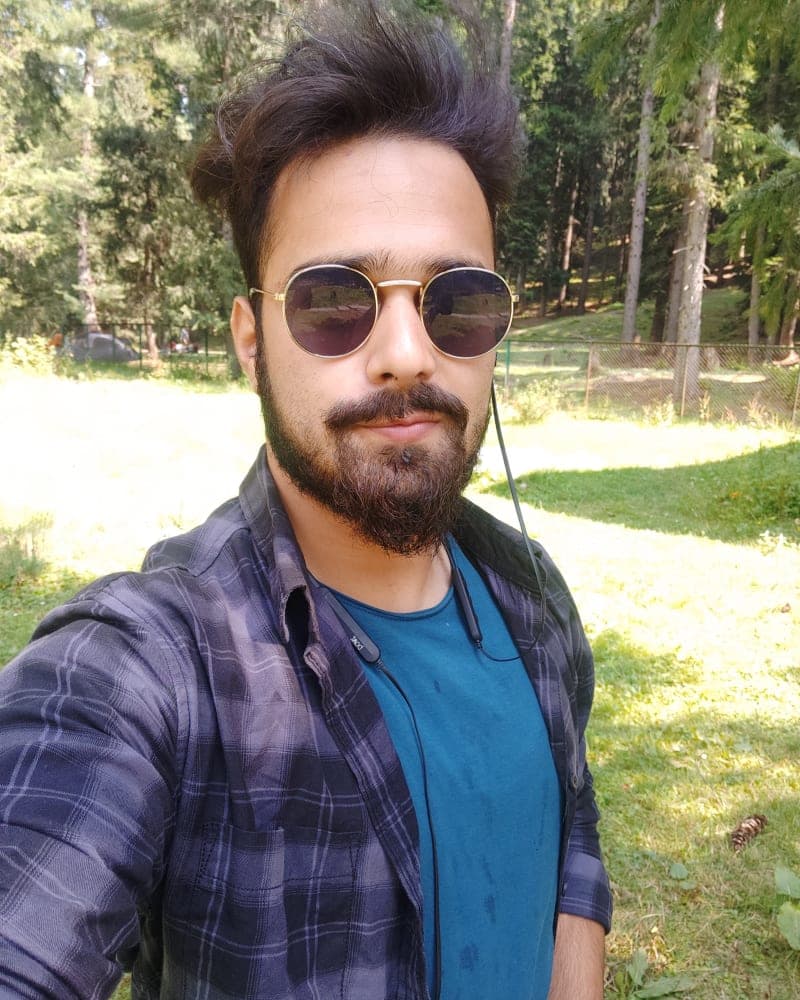 Muzamil Adnan outdoors in a pine forest in Kashmir